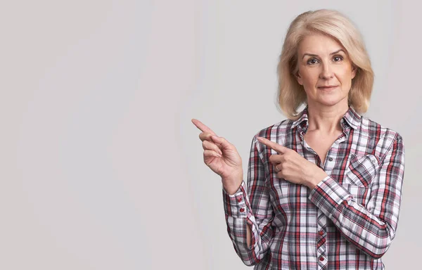 Hermosa mujer mayor señalando al espacio de copia —  Fotos de Stock