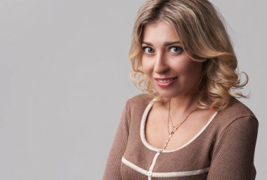 Oldukça adil saçlı kız gülümseyerek, kayıtsızca giyinmiş