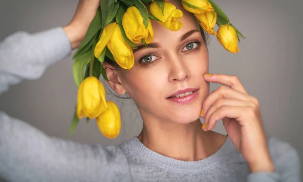 Gelukkig mooi meisje met gele tulpen — Stockfoto