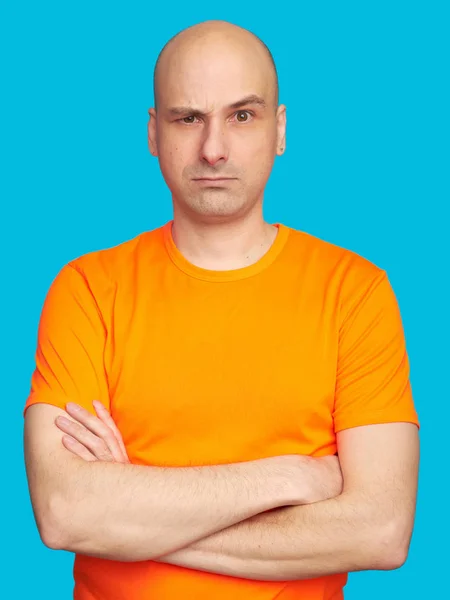 Ernstige doordachte kale man in oranje shirt — Stockfoto