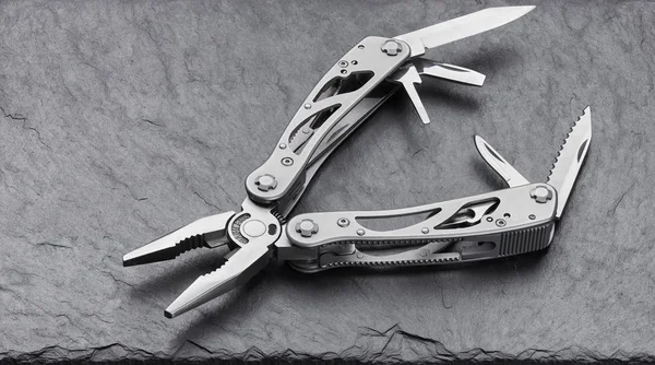 Multitool in acciaio su uno sfondo di pietra — Foto Stock