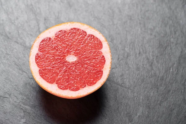 Свежий красный грейпфрут на каменном столе — стоковое фото