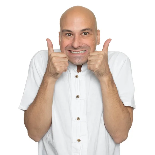 Szczęśliwy łysy mężczyzna w luźnej białej koszuli pokazuje kciuki do góry — Zdjęcie stockowe