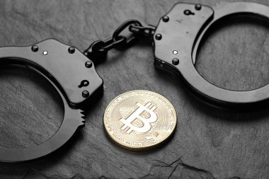 Taş zeminde Bitcoin ve siyah kelepçe