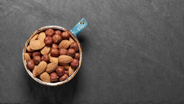 Nuts mix in a cup on stone background. Top view — Stock Photo, Image