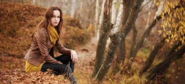 Sonbahar ormanındaki güzel esmer kadın.