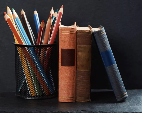 Oude boeken en potloden op een boekenplank — Stockfoto