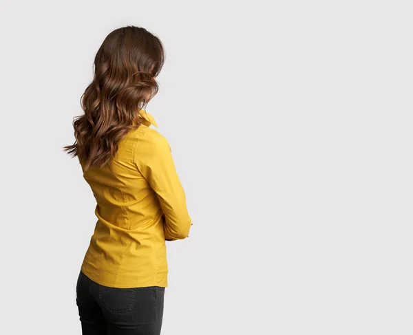 Vista posterior de una mujer de negocios en camisa amarilla está mirando hacia otro lado —  Fotos de Stock