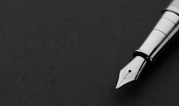 Close up of a fountain pen on a black paper — Stock Photo, Image