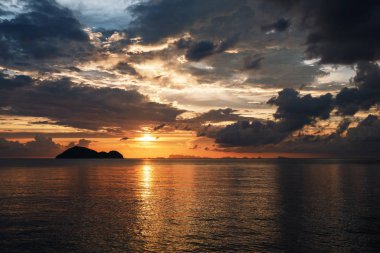 Deniz Günbatımı. Deniz Burnu. Bulutlu okyanus ve kızıl gökyüzü