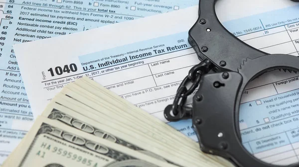 Handcuffs and tax form — 스톡 사진