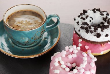 Bir fincan kahve ve şekerli donut.