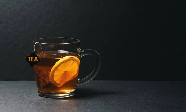 Glass of a black tea bag with lemon — Stock Photo, Image