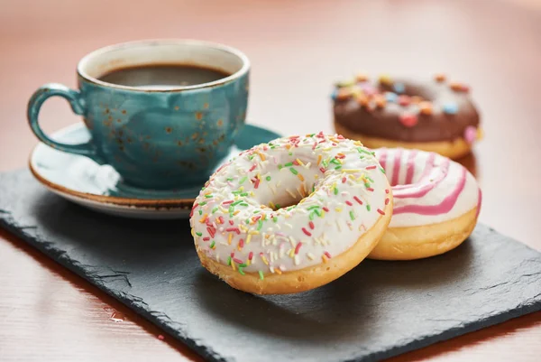 Xícara de café e donuts envidraçados com polvilhas — Fotografia de Stock