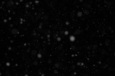 Kar. Siyah bir arkaplanda toz bulutu