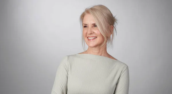 Senior mulher loira é dente sorrindo olhando para longe isolado — Fotografia de Stock