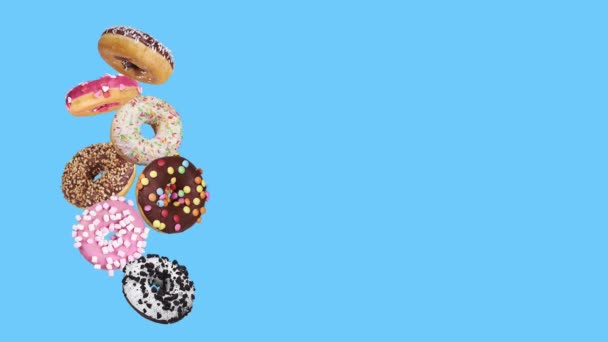 Mix Van Veelkleurige Zoete Donuts Met Hagelslag Blauwe Achtergrond — Stockvideo