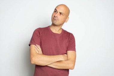 Ciddi kel adam yukarı bakıyor.