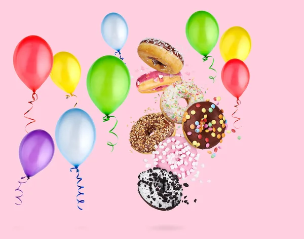 粉色背景的甜甜圈和气球 假日装饰 — 图库照片
