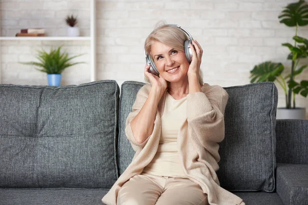 Mujer Mayor Despreocupada Está Escuchando Música Mientras Está Sentada Sofá —  Fotos de Stock