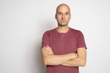 40 yaşında, kel bir adam gri arka planda izole edilmiş.