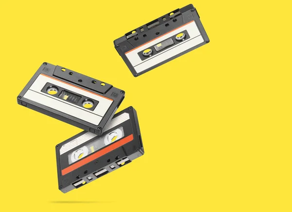 Old audio tape compact cassette isolated on yellow background.
