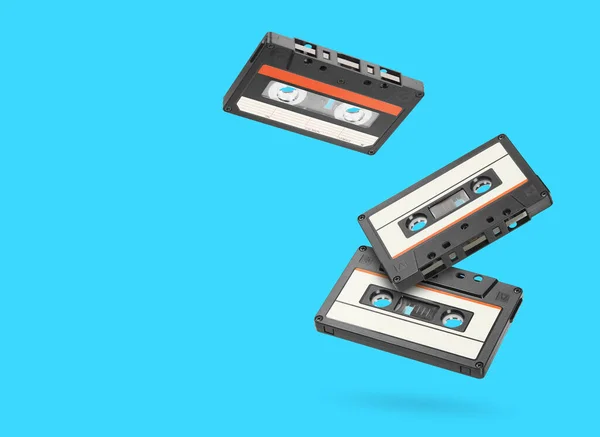 Three retro old audio tape cassettes over blue background