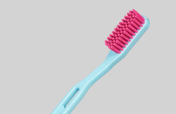 ブルーとピンクのプラスチックの歯ブラシがグレーの背景に横に — ストック写真