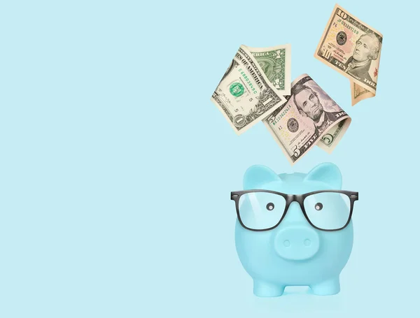 Piggy Bank Met Glazen Geïsoleerd Een Blauwe Achtergrond — Stockfoto