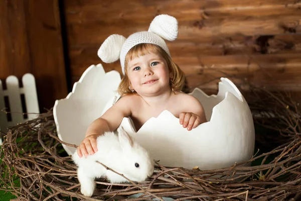 Pieni tyttö kanin korvat ja valkoinen pääsiäinen pupu — kuvapankkivalokuva