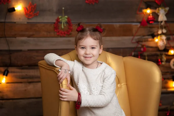 Маленькая девочка в красивом желтом кресле. Новогодний фон — стоковое фото