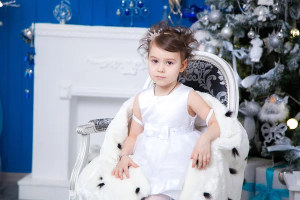 Lille prinsesse i bakgrunnen av et juletre – stockfoto
