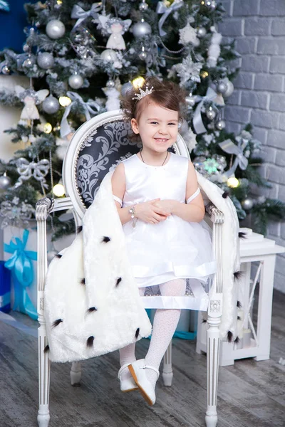 Pequena princesa no fundo de uma árvore de Natal — Fotografia de Stock