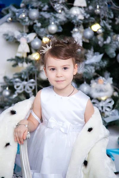 Pequena princesa no fundo de uma árvore de Natal — Fotografia de Stock