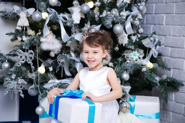 Menina abrindo presente de Natal na frente do abeto — Fotografia de Stock