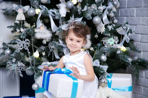 Menina abrindo presente de Natal na frente do abeto — Fotografia de Stock