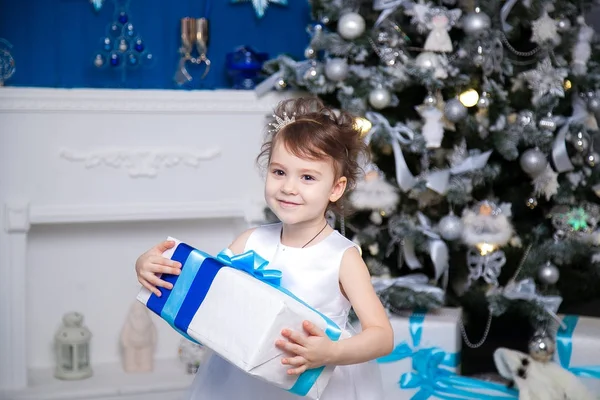 Menina abrindo presente de Natal na frente do abeto — Fotografia de Stock