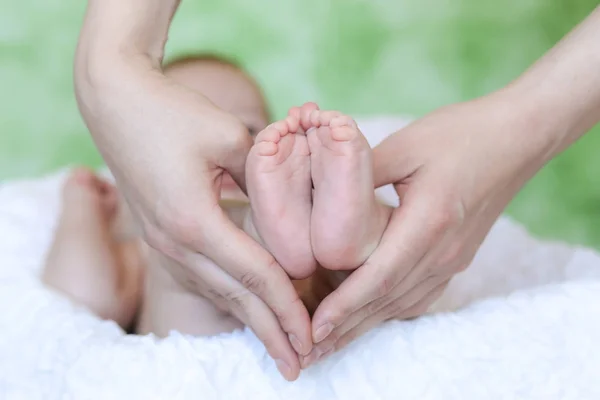 Pernas de bebê nas mãos da mãe — Fotografia de Stock