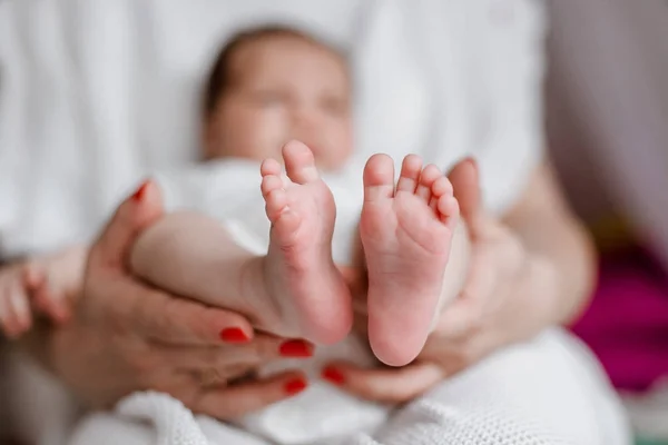 Pernas de bebê nas mãos da mãe — Fotografia de Stock