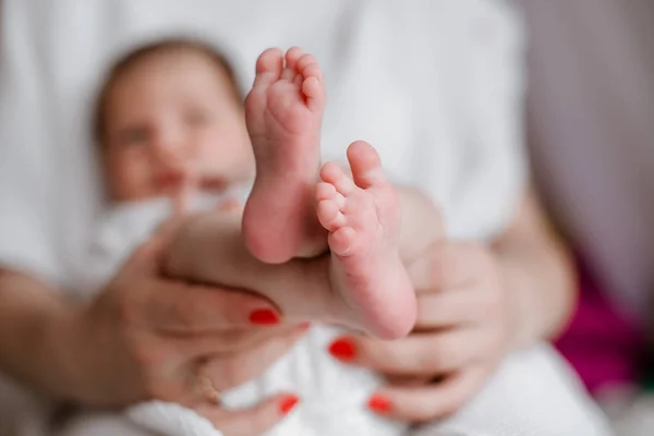 Pernas de bebê nas mãos da mãe — Fotografia de Stock