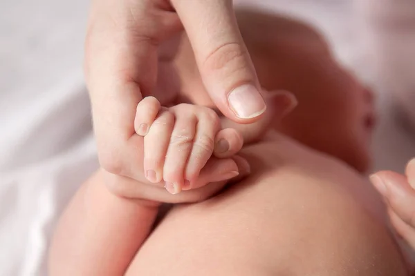 O bebê está segurando a mão da mãe — Fotografia de Stock