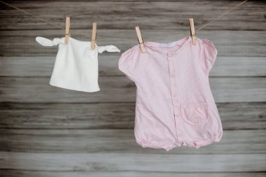 Clothespin üzerinde asılı bebek giysileri.