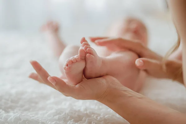 Pernas de bebê nas mãos da mãe — Fotografia de Stock