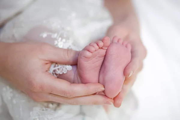 Benen van de baby in moeder's handen — Stockfoto