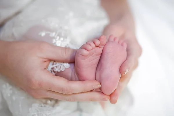 Gambe del bambino nelle mani della madre — Foto Stock