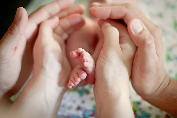 Gambe del bambino nelle mani della madre — Foto Stock