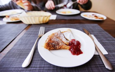 Reçelli krep ve beyaz tabakta pudra şekeri. Taze sabah