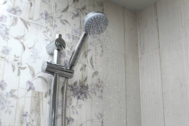Steel shower spray in the bathroom. clipart