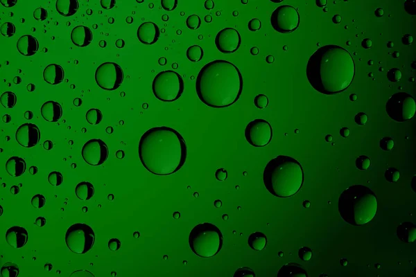 Água gotejada em vidro. Fundo abstrato verde — Fotografia de Stock