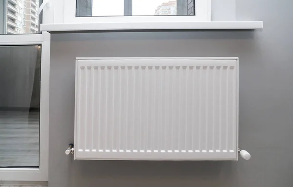 Radiador de calefacción en la pared debajo de la ventana. El apartamento es — Foto de Stock